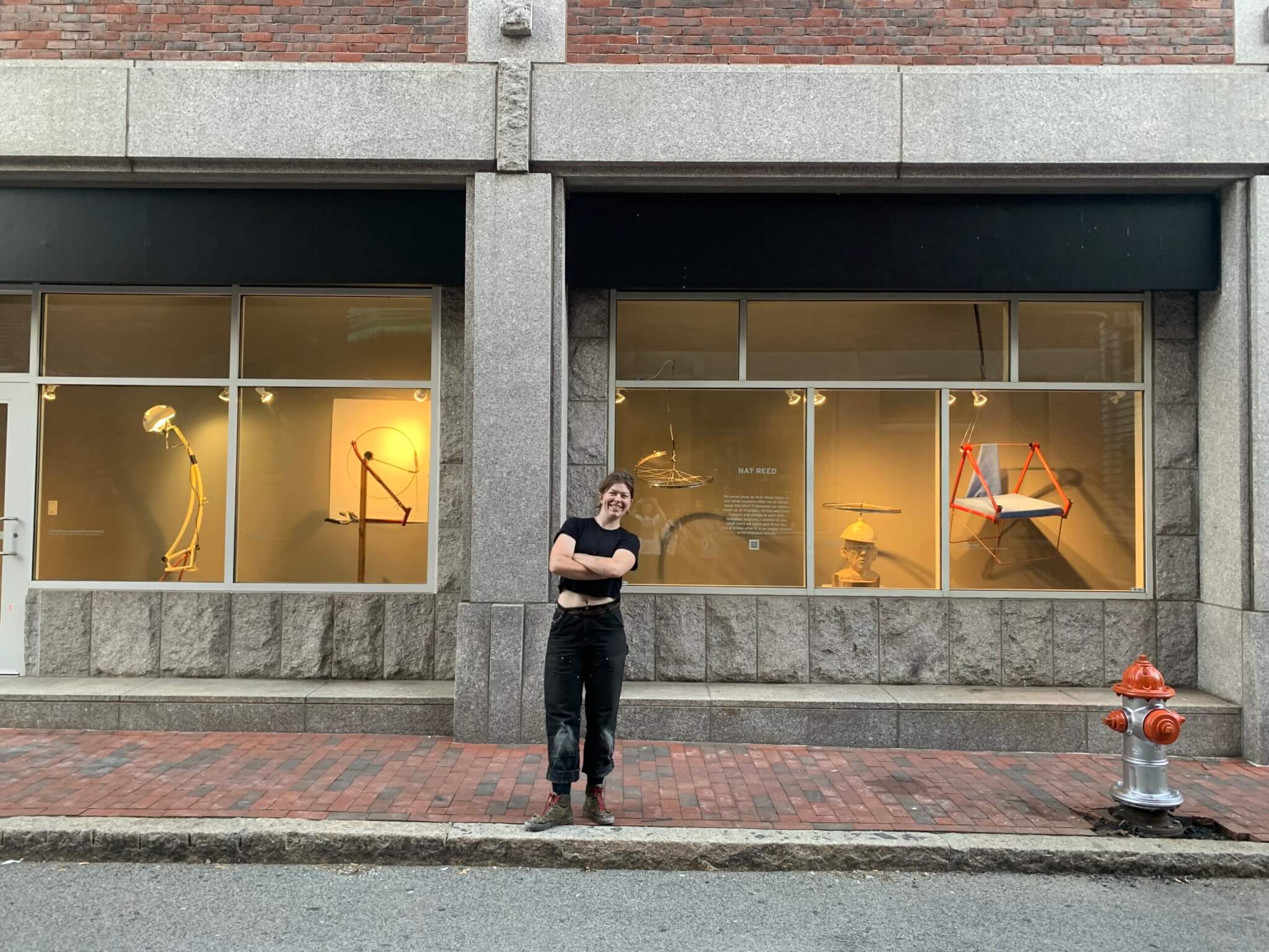 Image of artist Nat Reed in front of "Bikes Move Us" installation
