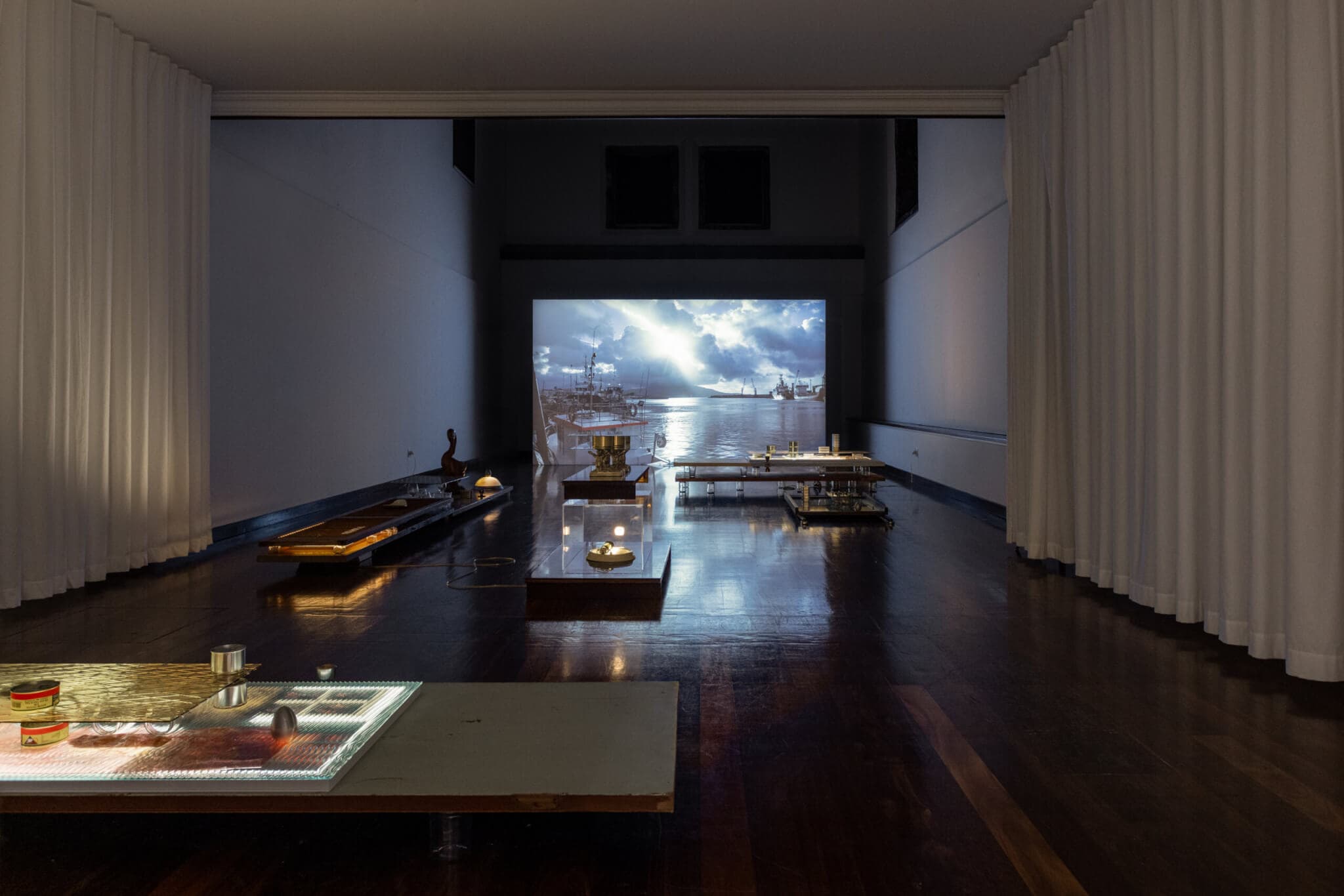 A projected video shows a seascape and stormy sky.